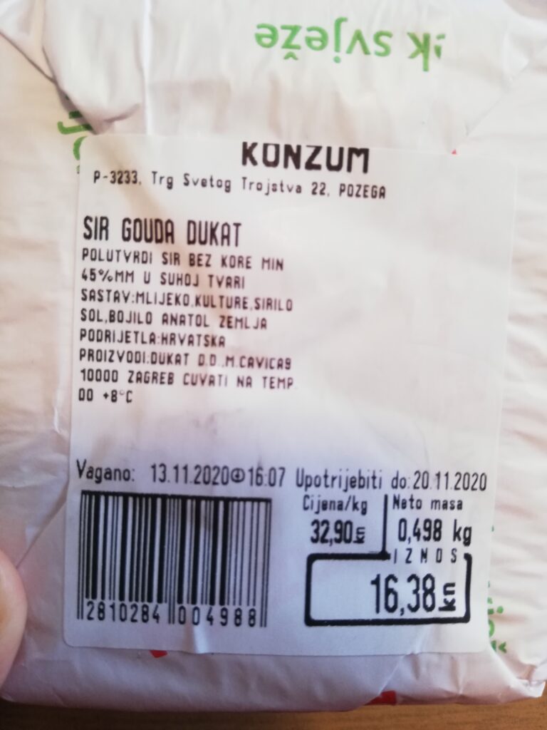 スーパーマーケットの売り場で購入したチーズに包み紙が巻かれて値段が書かれている